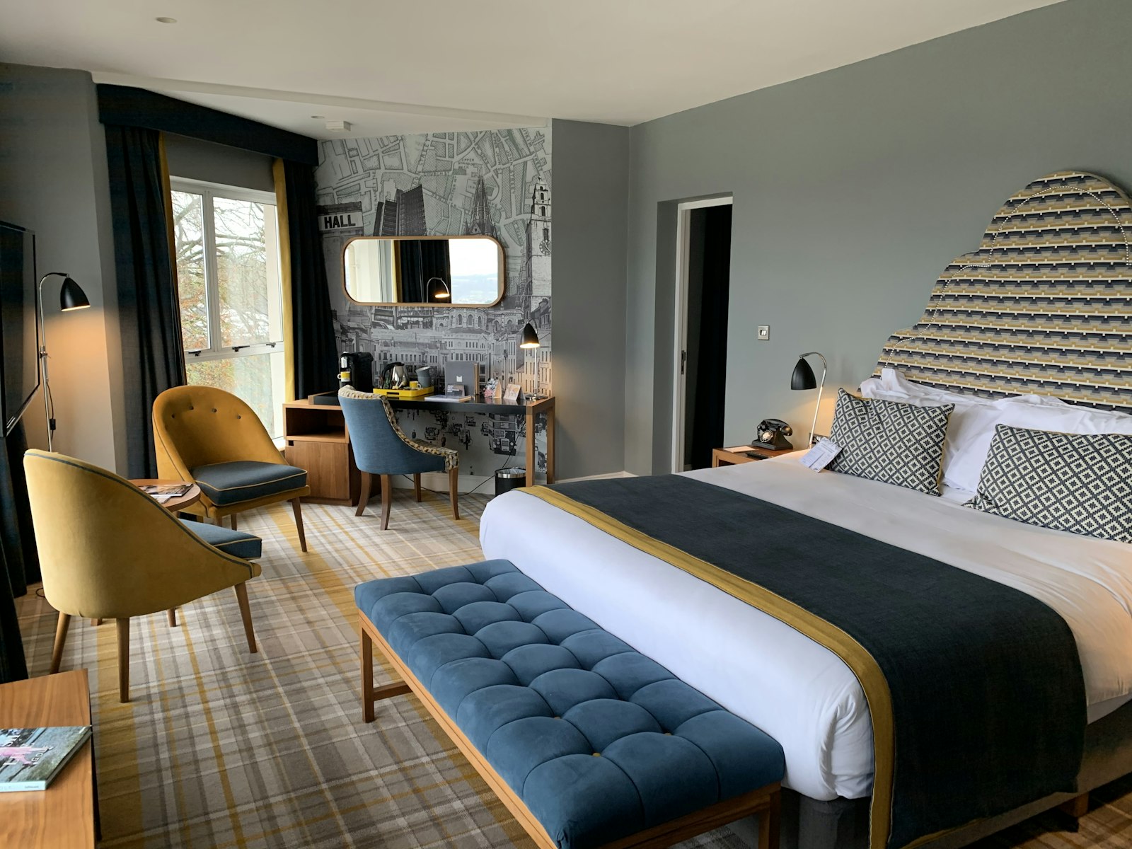 Corner suite with an unmade linen bed, morning light and a window seat over the city